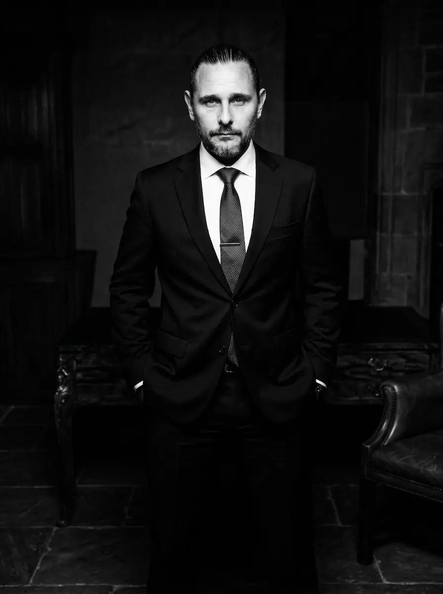 A black and white photo of the founder of Fkn Manly soap, Mike Sampson wearing a black suit.